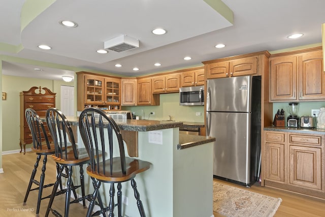 1301 N Western Ave Unit 317, Lake Forest, IL 60045 - kitchen featuring stainless steel appliances, a breakfast bar area, recessed lighting, light wood-style flooring, and glass insert cabinets