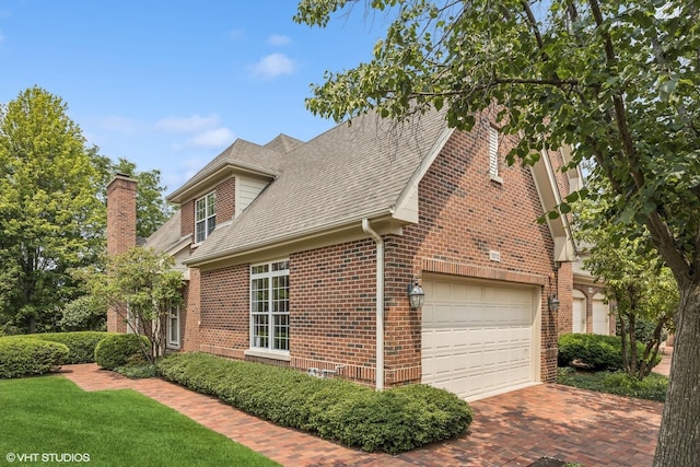 1012 Hickory Dr, Western Springs, IL 60558 - view of property exterior with brick siding, a shingled roof, decorative driveway, and a chimney