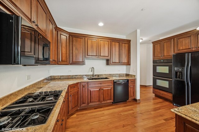 1012 Hickory Dr, Western Springs, IL 60558 - kitchen featuring black appliances, light wood-style floors, light stone countertops, brown cabinets, and recessed lighting