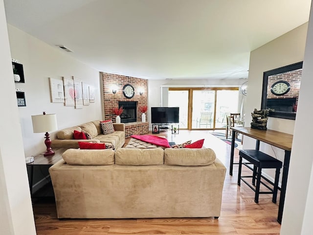 15721 Old Orchard Ct Unit 2S, Orland Park, IL 60462 - living area with a brick fireplace and light wood-style flooring