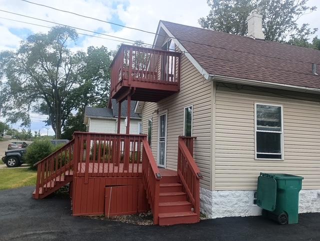 213 Edward St, Joliet, IL 60436 - view of home's exterior with stairway, a shingled roof, a chimney, and a deck