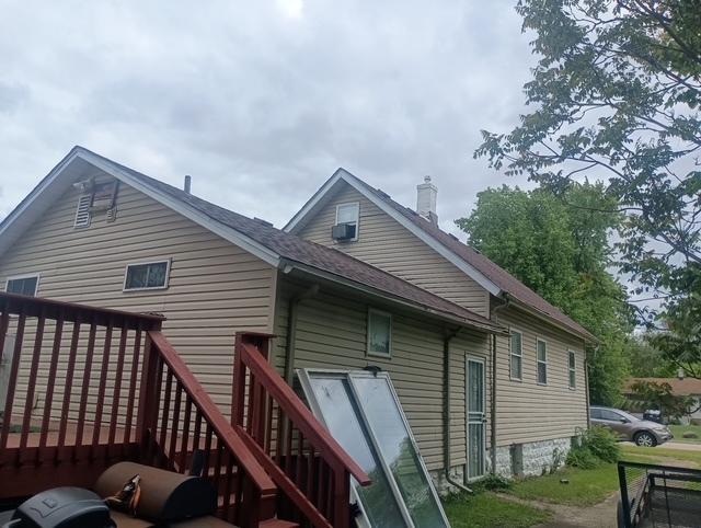 213 Edward St, Joliet, IL 60436 - rear view of house featuring a chimney, a shingled roof, and cooling unit