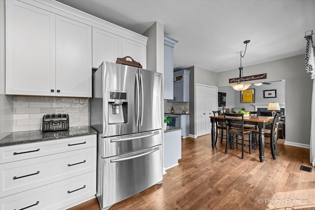 2171 Edinburgh Ln, Aurora, IL 60504 - kitchen featuring stainless steel fridge, tasteful backsplash, dark wood finished floors, dark stone counters, and white cabinets