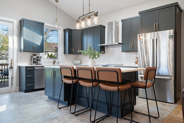 7929 N Octavia Ave, Niles, IL 60714 - kitchen featuring appliances with stainless steel finishes, wall chimney range hood, vaulted ceiling, light countertops, and a kitchen island