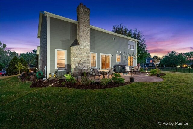 1714 Tall Tree Ln, Johnsburg, IL 60051 - back of house at dusk featuring a patio and a chimney
