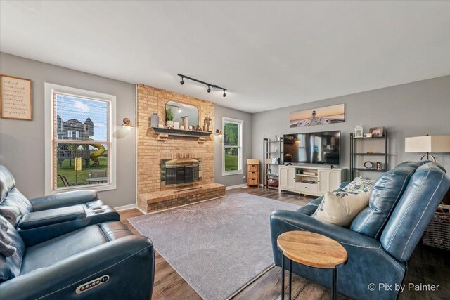 1714 Tall Tree Ln, Johnsburg, IL 60051 - living area with wood finished floors, rail lighting, and a brick fireplace