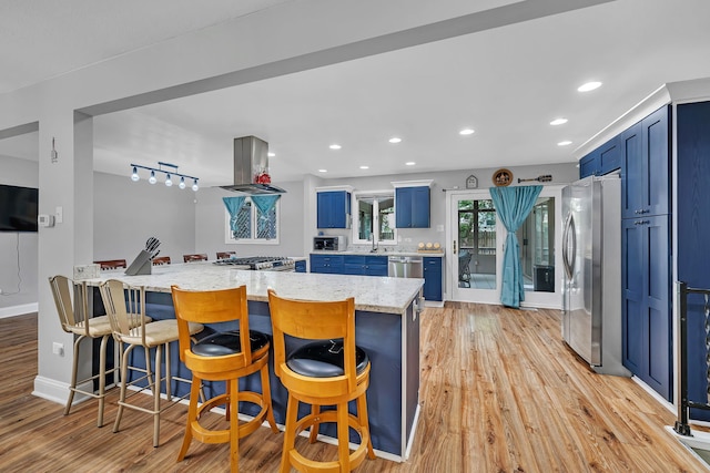 1810 Jana Ln, Morris, IL 60450 - kitchen with blue cabinets, appliances with stainless steel finishes, island exhaust hood, light wood-style floors, and a kitchen breakfast bar