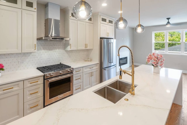 7431 W Forest Preserve Ave, Chicago, IL 60634 - kitchen with wall chimney range hood, stainless steel appliances, decorative backsplash, decorative light fixtures, and a ceiling fan