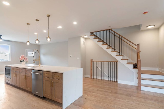 7431 W Forest Preserve Ave, Chicago, IL 60634 - kitchen with stainless steel dishwasher, light wood-type flooring, decorative light fixtures, light countertops, and recessed lighting