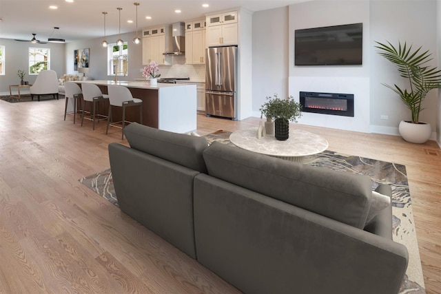 7431 W Forest Preserve Ave, Chicago, IL 60634 - living area featuring light wood finished floors, a glass covered fireplace, and recessed lighting