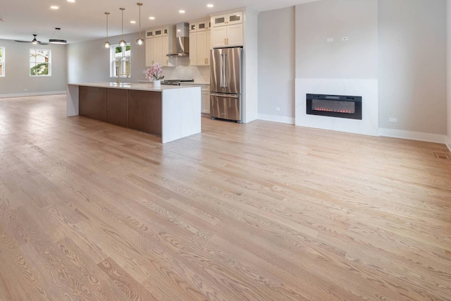 7431 W Forest Preserve Ave, Chicago, IL 60634 - kitchen with freestanding refrigerator, open floor plan, wall chimney range hood, light wood-type flooring, and recessed lighting