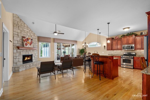 13150 S Lake Mary Dr, Plainfield, IL 60585 - kitchen featuring appliances with stainless steel finishes, lofted ceiling, open floor plan, a kitchen bar, and light wood-style flooring