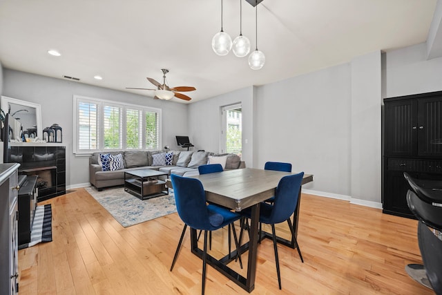 3021 W Armitage Ave Unit 201, Chicago, IL 60647 - dining space with light wood-style floors, a ceiling fan, recessed lighting, and a tile fireplace
