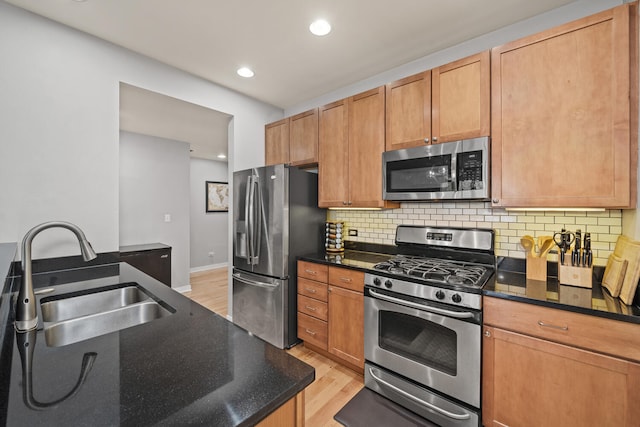 3021 W Armitage Ave Unit 201, Chicago, IL 60647 - kitchen featuring stainless steel appliances, light wood-style flooring, decorative backsplash, recessed lighting, and dark stone counters