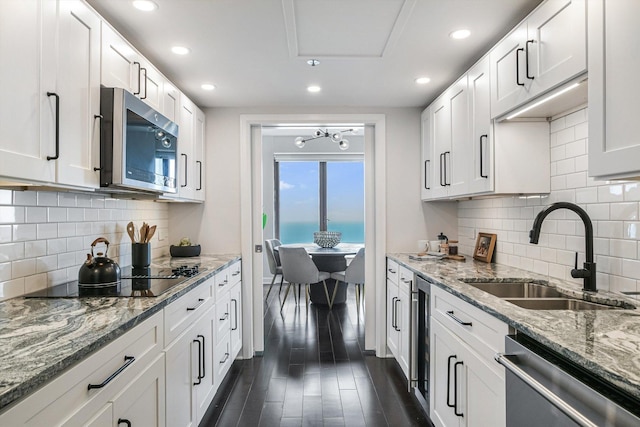 161 E Chicago Ave Unit 49B, Chicago, IL 60611 - kitchen featuring appliances with stainless steel finishes, recessed lighting, white cabinets, dark wood finished floors, and tasteful backsplash