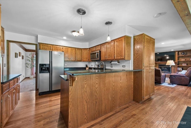 42W412 Sylvan Ln, Saint Charles, IL 60175 - kitchen with appliances with stainless steel finishes, dark countertops, brown cabinetry, hardwood / wood-style floors, and recessed lighting