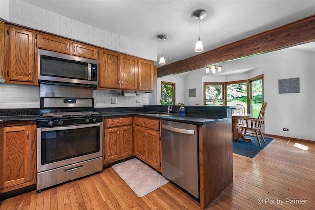 42W412 Sylvan Ln, Saint Charles, IL 60175 - kitchen with stainless steel appliances, tasteful backsplash, a peninsula, brown cabinetry, and beamed ceiling