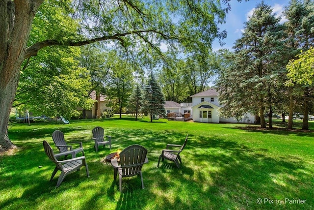 42W412 Sylvan Ln, Saint Charles, IL 60175 - view of grassy yard featuring a trampoline and a fire pit