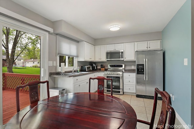 1113 Rolling Lane Rd, Johnsburg, IL 60051 - kitchen featuring stainless steel appliances, dark countertops, white cabinetry, and light tile patterned floors