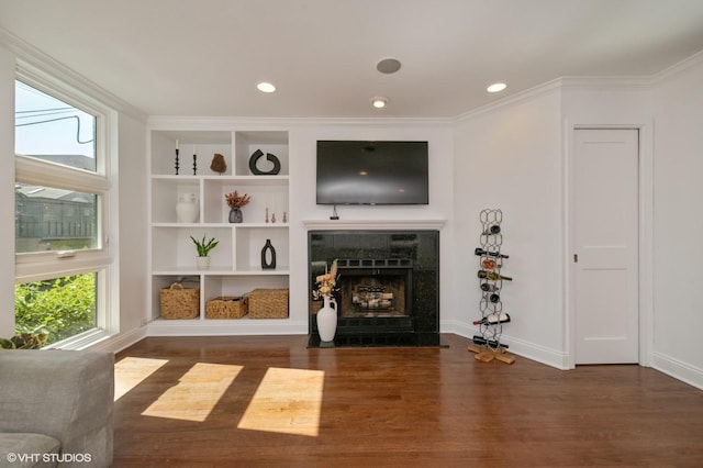 1719 N Halsted St Unit C, Chicago, IL 60614 - unfurnished living room featuring healthy amount of natural light, wood finished floors, a tiled fireplace, built in shelves, and crown molding