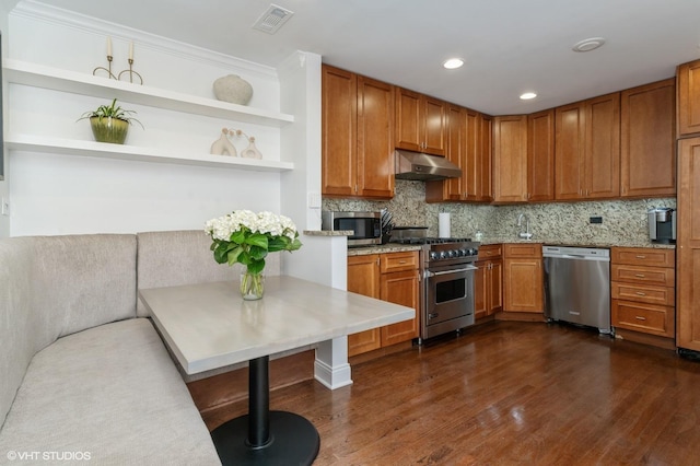 1719 N Halsted St Unit C, Chicago, IL 60614 - kitchen featuring stainless steel appliances, under cabinet range hood, dark wood-style floors, brown cabinetry, and backsplash