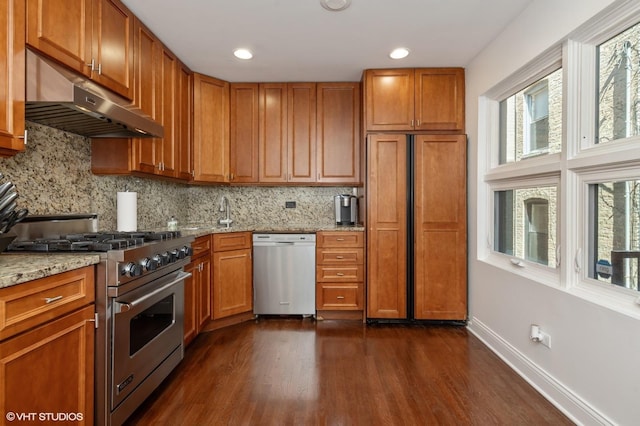 1719 N Halsted St Unit C, Chicago, IL 60614 - kitchen with high end appliances, under cabinet range hood, dark wood finished floors, tasteful backsplash, and brown cabinets