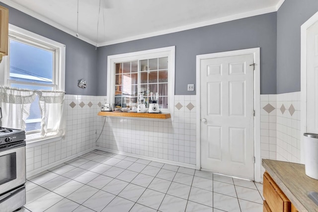 4036 N Bernard St, Chicago, IL 60618 - kitchen with tile walls, stainless steel stove, a wainscoted wall, light tile patterned flooring, and plenty of natural light