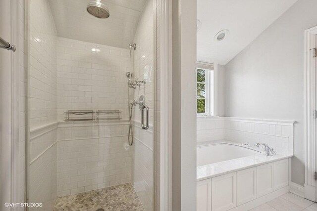 2642 Prairie Ave Unit 2, Evanston, IL 60201 - bathroom featuring a stall shower, a bath, vaulted ceiling, and tile patterned flooring