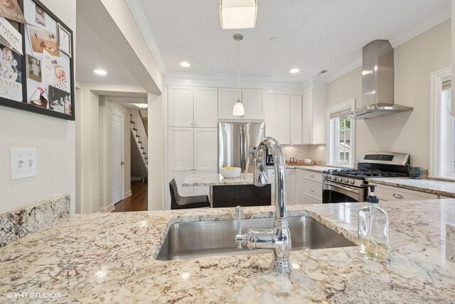 2642 Prairie Ave Unit 2, Evanston, IL 60201 - kitchen with wall chimney exhaust hood, stainless steel appliances, ornamental molding, light stone counters, and white cabinetry