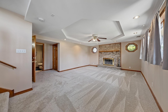 7749 W Lakeview Ter, Frankfort, IL 60423 - unfurnished living room with a ceiling fan, a tray ceiling, carpet flooring, recessed lighting, and a brick fireplace