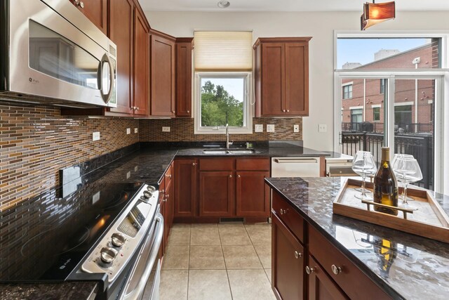 319 W Wood St Unit 18, Palatine, IL 60067 - kitchen with stainless steel appliances, decorative backsplash, dark stone countertops, and light tile patterned floors