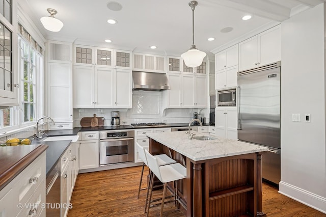 625 Park Ave, Wilmette, IL 60091 - kitchen with built in appliances, exhaust hood, dark wood-type flooring, decorative backsplash, and white cabinetry