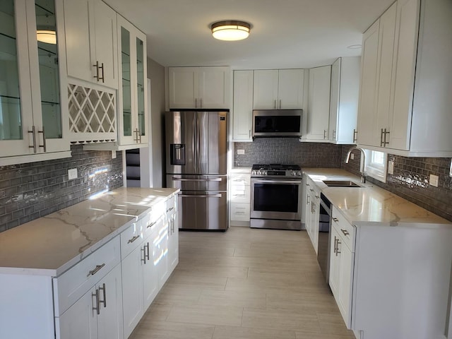 542 Laramie Ave, Wilmette, IL 60091 - kitchen with stainless steel appliances, tasteful backsplash, light stone countertops, and white cabinetry