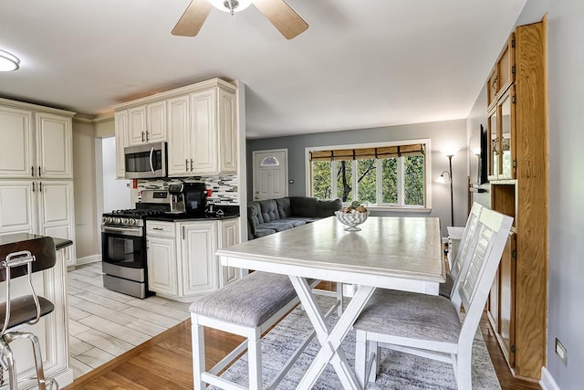 15005 131st St, Lemont, IL 60439 - kitchen featuring stainless steel appliances, light wood-type flooring, dark countertops, and a ceiling fan