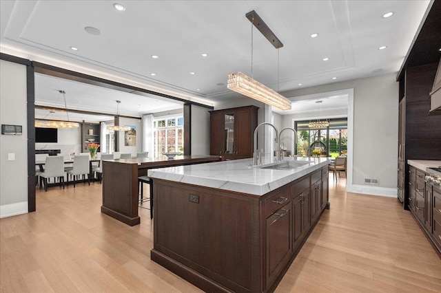 326 Country Ln, Glenview, IL 60025 - kitchen with a large island with sink, a chandelier, light wood-style flooring, and recessed lighting