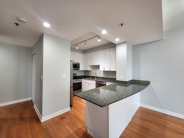 1250 S Michigan Ave Unit 703, Chicago, IL 60605 - kitchen with appliances with stainless steel finishes, baseboards, white cabinetry, a peninsula, and light wood finished floors