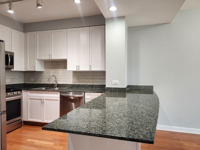1250 S Michigan Ave Unit 703, Chicago, IL 60605 - kitchen featuring a sink, stainless steel appliances, a peninsula, light wood-type flooring, and white cabinetry