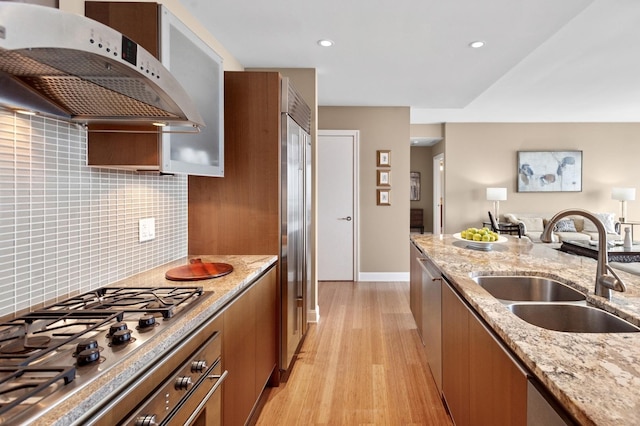 340 E Randolph St Unit 5504, Chicago, IL 60601 - kitchen with exhaust hood, appliances with stainless steel finishes, brown cabinets, light wood-style flooring, and backsplash