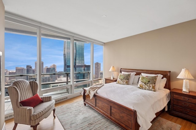 340 E Randolph St Unit 5504, Chicago, IL 60601 - bedroom featuring a view of skyline, wood finished floors, and a wall of windows