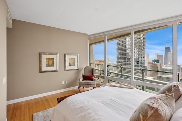 340 E Randolph St Unit 5504, Chicago, IL 60601 - bedroom with a skyline view, multiple windows, access to outside, a wall of windows, and wood finished floors
