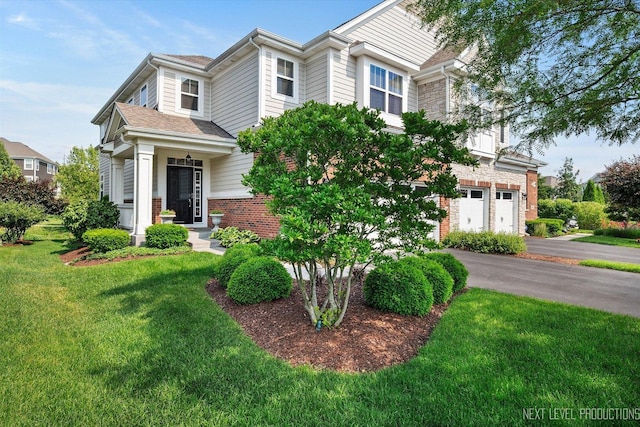 3S661 Breme Dr W, Warrenville, IL 60555 - view of front of property with a garage, brick siding, driveway, and a front lawn