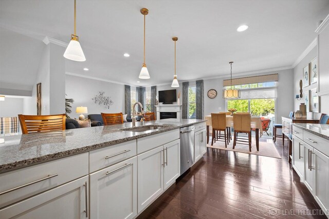 3S661 Breme Dr W, Warrenville, IL 60555 - kitchen with ornamental molding, stainless steel dishwasher, open floor plan, a fireplace, and white cabinets