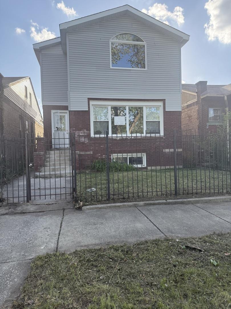 7736 S Oglesby Ave, Chicago, IL 60649 - view of front of home with brick siding, a fenced front yard, and a gate