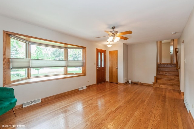 25W251 Highview Dr, Naperville, IL 60563 - unfurnished living room featuring healthy amount of natural light, light wood-type flooring, a ceiling fan, and stairs