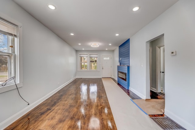 unfurnished living room with recessed lighting, a large fireplace, and wood finished floors