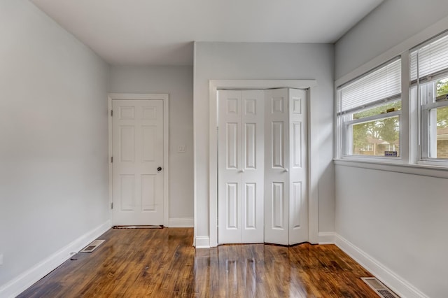 unfurnished bedroom with a closet and wood finished floors