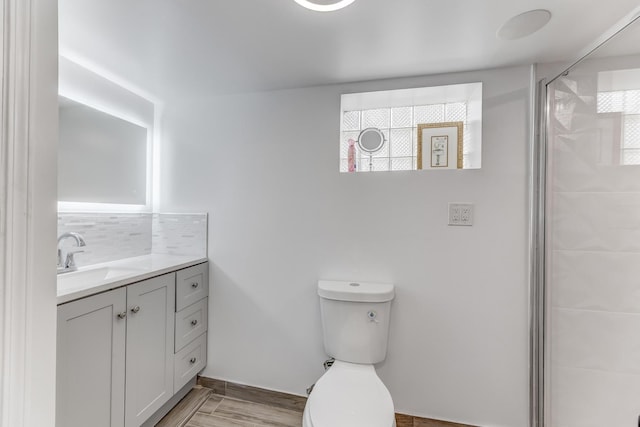 bathroom featuring vanity, a shower stall, tasteful backsplash, and healthy amount of natural light