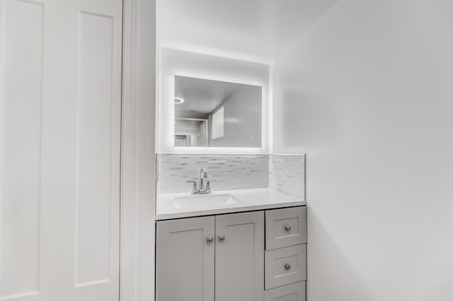 bathroom featuring vanity and backsplash