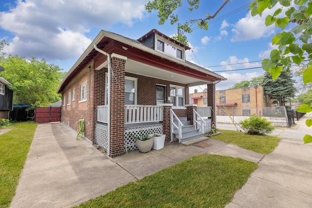 bungalow-style home featuring brick siding and covered porch