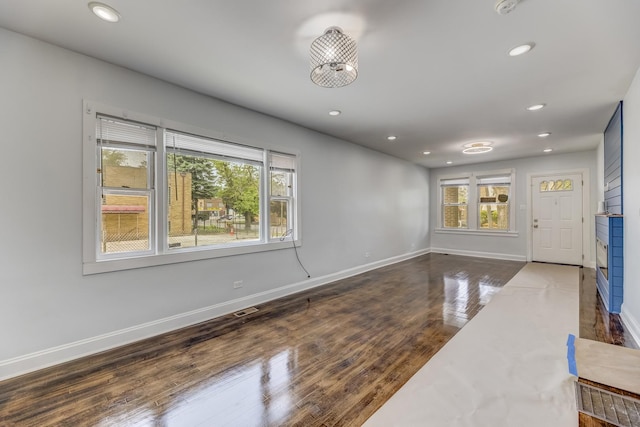 empty room with healthy amount of natural light, recessed lighting, and wood finished floors